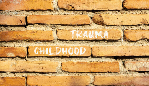 Childhood trauma symbol. Concept words Childhood trauma on beautiful brick wall. Beautiful red brown brick wall background. Business psychology childhood trauma concept. Copy space.