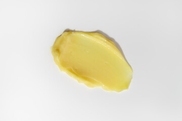 Yellow beauty cream smear smudge on white background. Cosmetic skincare product texture.