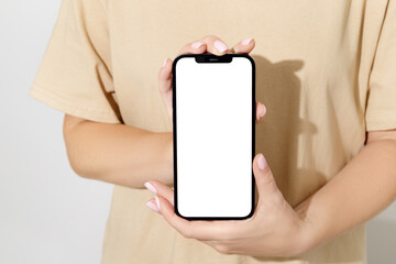 Female hands holding cell phone with blank screen. Mockup
