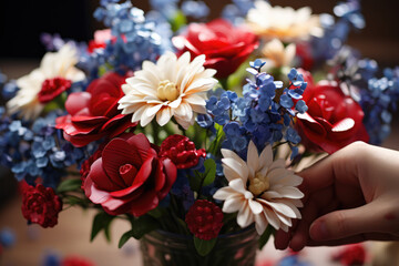 A close-up of a person's hand arranging a bouquet of red, white, and blue flowers in honor of the French flag. Generative Ai.