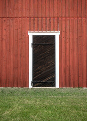 Old black wooden door on red farm building
