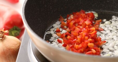 Add paprika or sweet pepper to the fried onions in the pan.. Cooking bolognese sauce. Food preparation in the kitchen. A series of photos to visualize the recipe.