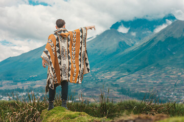Model wearing a poncho handmade with sheep cloth by the indigenous Kichwa artisan communities of the area, posing at the San Pablo lake in Otavalo, Ecuador. - obrazy, fototapety, plakaty