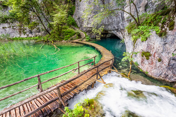 Scenic view of wooden deck over waterfall surrounded by mountains at Plitvice Lakes National Park in Croatia