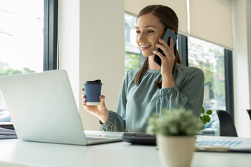 Businessman working at desk using laptop.