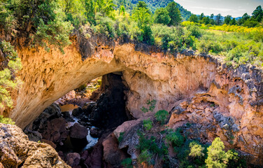 People stand near the river running through Tonto Natural Bridge in Payson Arizona