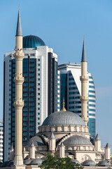 minaret of traditional Islamic mosque and tall modern skyscrapers in Grozny Chechnya