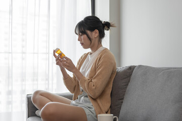 Asian woman Search for information on Internet in smartphone with holding bottled drug. girl reading information online on mobile phone medicine healthcare product concept.