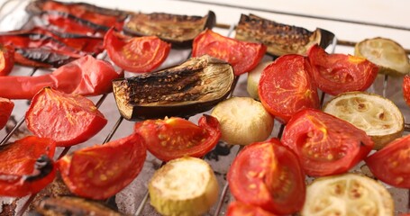 Cooking grilled vegetables. A tray from the oven with grilled vegetables on the table. Food preparation. Close-up.