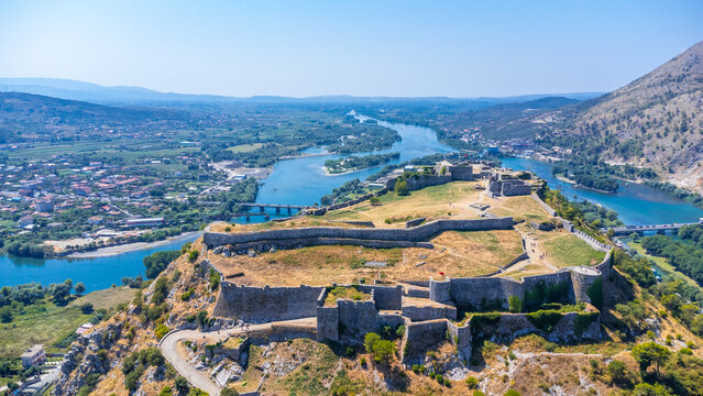Aerial drone view of Rozafa Castle in the city Shkoder and its walls next to the lake and the river. Albania