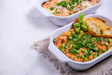 Oven baked frittata with mediterranen vegetables such as zucchini, tomatoes, bell peppers and red onions. Served in a rustic cast.Horizontal photo, space for text