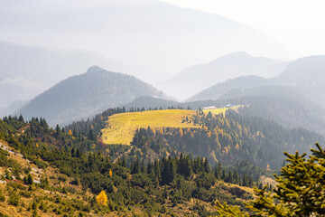 Astonishing scene of mountain range horizon in the morning mist, illuminated by the light of the...