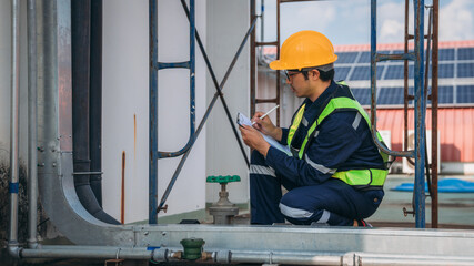 A team of engineers is checking the air conditioning cooling system of a major building or...