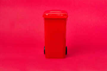 Trash can with paper inside on red background. Recycle concept.
