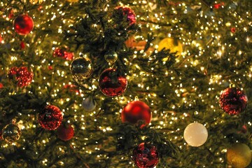 Background from a luminous Christmas garland and balls on a Christmas tree