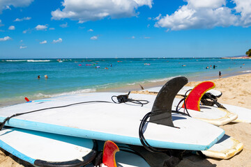 Waikiki beach in Honolulu, Hawaii, with surfboards and ocean view. Defocused background of unrecognizable people.