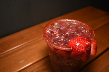 Toma a detalle de una bebida alcoholica de fresas y frutos rojos llamado mojito 