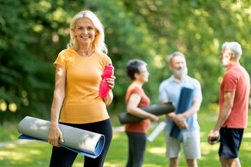 Portrait Of Beautiful Sporty Senior Woman Training Outside With Group Of Friends