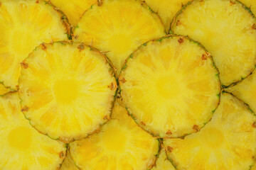 Pineapple juicy yellow slices as a background.