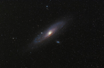 Andromeda Galaxy (M31) and its satellite galaxies (M32 and M110) in Andromeda constellation against widefield night starry sky