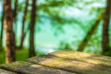  Empty wooden table top on of blurred blue lake background, sunlight, spring, copy space
