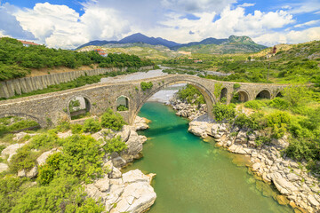 Fototapeta na wymiar historic Mesi Bridge in Albania. visitors to marvel at its exquisite beauty, immerse themselves in picturesque natural surroundings, and honor rich heritage of this historical landmark. aerial view