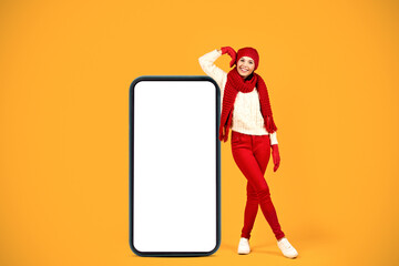 Happy Young Woman Leaning On Big Cellphone Screen, Yellow Background