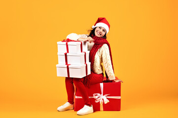 Happy Lady Posing With Many Christmas Gifts Over Yellow Background