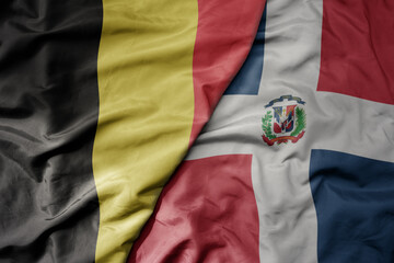 big waving national colorful flag of belgium and national flag of dominican republic .