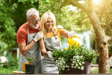 Retirement Activities. Happy Senior Spouses Gardening Together On Backyard - Powered by Adobe