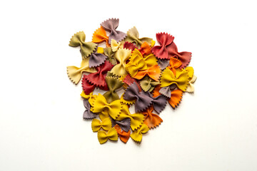 butterfly-shaped Italian pasta of various colors ,colored pasta on a white background, an ingredient of Italian cuisine