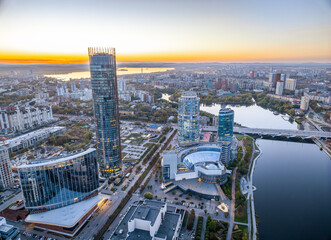 Obraz premium Yekaterinburg city and pond aerial panoramic view at summer or early autumn sunset. Night city in the early autumn or summer.