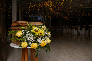 Salón de eventos decorado con flores amarillas, blancas y rosadas