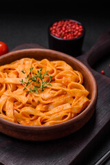 Delicious fresh pasta with pesto sauce, salt, spices and herbs on a ceramic plate