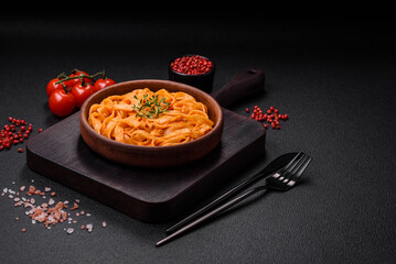 Delicious fresh pasta with pesto sauce, salt, spices and herbs on a ceramic plate