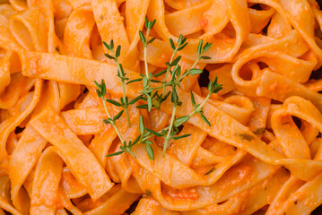 Delicious fresh pasta with pesto sauce, salt, spices and herbs on a ceramic plate