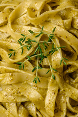 Delicious fresh pasta with pesto sauce, salt, spices and herbs on a ceramic plate