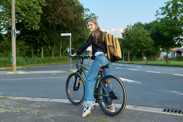 Obraz premium Portrait of teenage student girl with backpack on bicycle