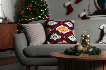 Interior of dark living room with grey sofa, coffee table and Christmas tree
