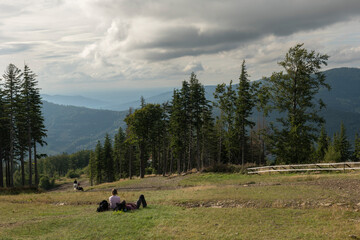 Górskie wędrówki, wakacje, dziewczyna i chłopak leży na trawie i podziwia piękne góry,...