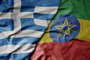 big waving national colorful flag of greece and national flag of ethiopia .