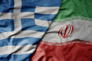big waving national colorful flag of greece and national flag of iran .