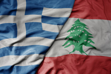 big waving national colorful flag of greece and national flag of lebanon .