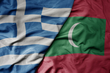 big waving national colorful flag of greece and national flag of maldives .