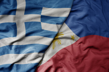 big waving national colorful flag of greece and national flag of philippines .