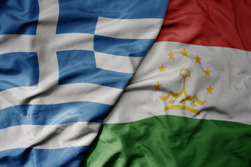 Fototapeta premium big waving national colorful flag of greece and national flag of tajikistan .