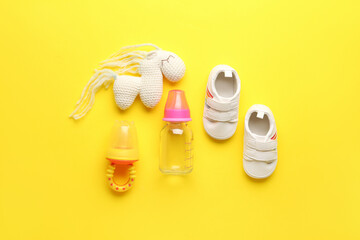 Set of baby accessories on yellow background