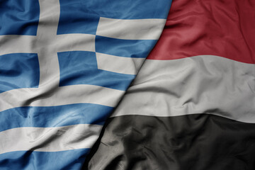 big waving national colorful flag of greece and national flag of yemen .