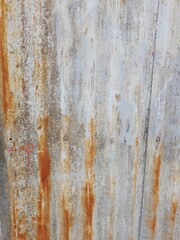 La pared de chapa acanalada de un cobertizo de cereales, vieja y oxidada por fuera, forma un diseño industrial original y hermoso para fondos texturizados