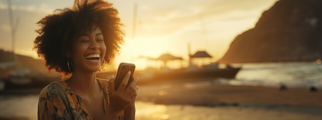Backlit Portrait of calm happy smiling free black woman laughing at her smartphone camera enjoying a beautiful moment life on the seashore at sunset